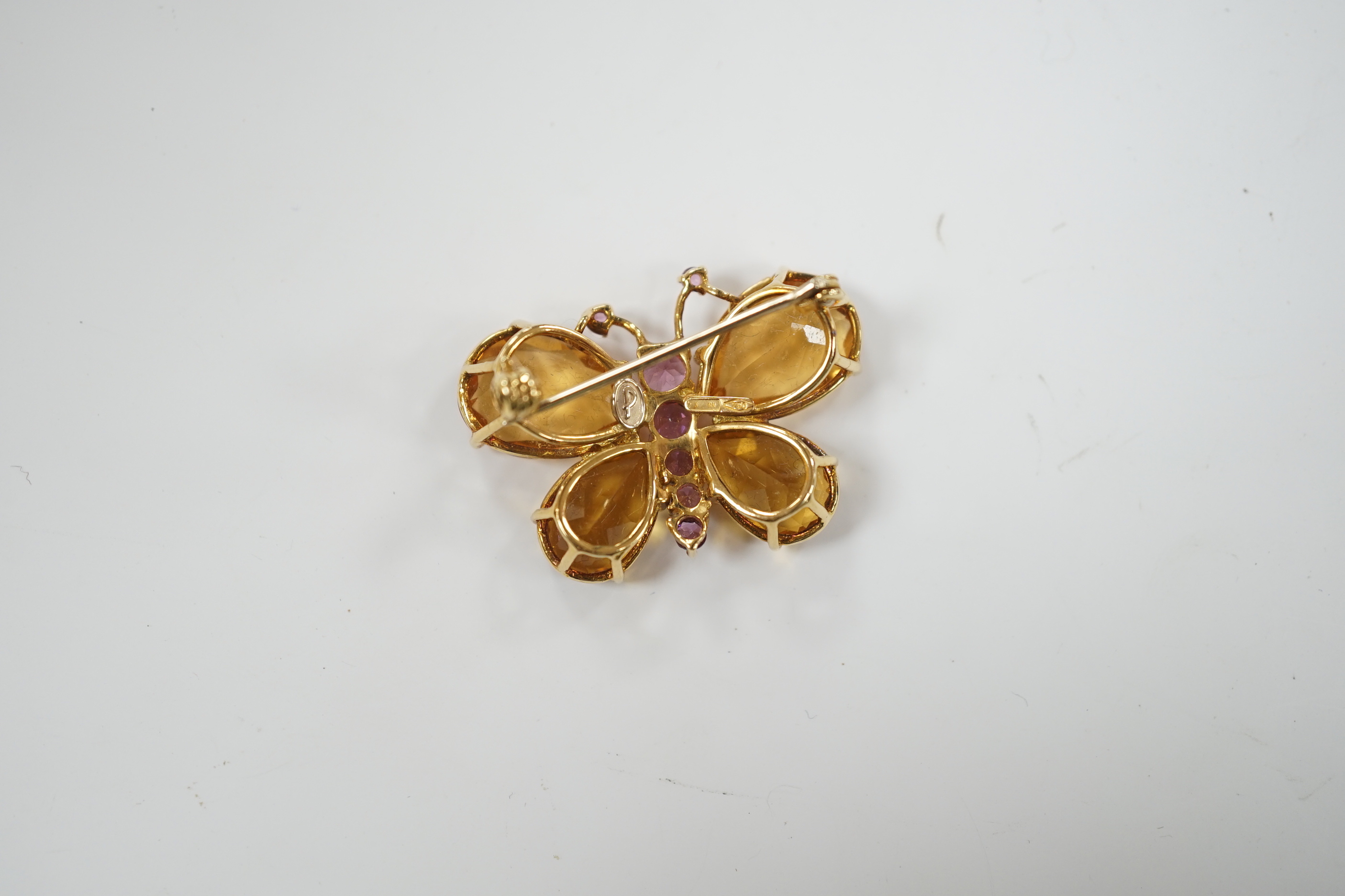 A modern Italian 750 yellow metal, four stone citrine and graduated seven stone pink sapphire set butterfly brooch, width 32mm, gross weight 8.1 grams.